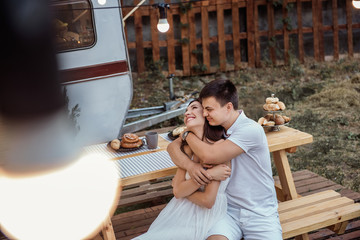 Beautiful young couple having fun while traveling on their trailer. Honeymoon trip of a young couple around the world on a trailer.