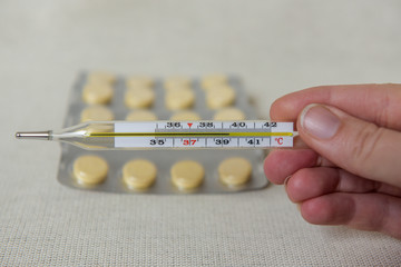 Pills in blister packs, close up. Healthcare and medicine concept. Pills and thermometer on a white...