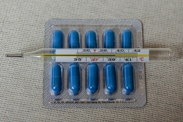Pills in blister packs, close up. Healthcare and medicine concept. Pills and thermometer on a white...