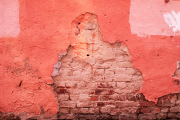 Bright pink stucco on an old painted brick wall