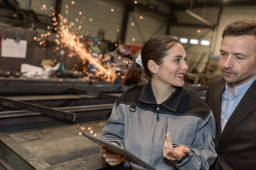 Female worker explains technical issue to her boss using a tablet