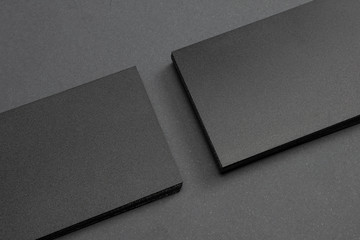 2 stacks of black blank textured business cards on dark paper background, us size 3.5 x 2 inches, as template for design presentation.