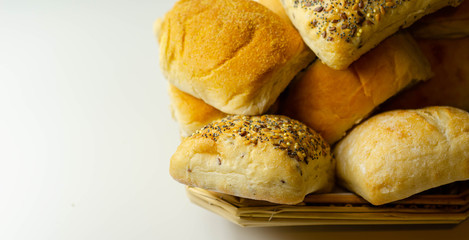 Various types of bread served on a wicker tray, delicious and fresh rolls