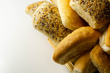 Various types of bread served on a wicker tray, delicious and fresh rolls
