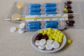 Pills in blister packs, close up. Healthcare and medicine concept. Pills and thermometer on a white...