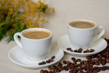 Two cups of fresh espresso with coffee beans. Sprinkled coffee beans. Morning coffee concept