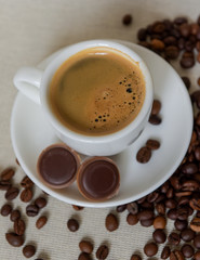 A cup of fresh espresso with chocolates. Coffee beans. Morning coffee concept