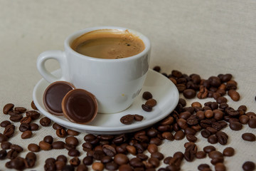 A cup of fresh espresso with chocolates. Coffee beans. Morning coffee concept