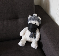 Soft toys bears in a black medical masks sit on a black sofa. Schools and kindergartens are under quarantine. Home schooling. 