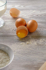 Fresh and tasty white loaf with crisp and ingredients for the recipe on a wooden table