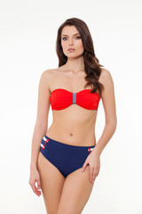 Fototapeta premium beautiful girl posing in stylish designed chic coral and navy blue bikini on white background.