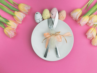 Easter table cutlery with tulips, feathers and bow