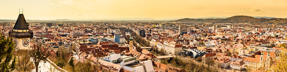 Fototapeta na wymiar Panoramic view at Graz city with his famous buildings. River mur, clock tower, art museum, town hall.