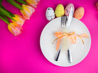 Easter table cutlery with tulips, feathers and bow