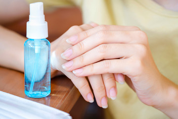 Closeup Women wash hands, blue alcohol gel bottles for cleaning and medical surgical masks for stop corona virus outbreak.Wuhan coronavirus and epidemic virus symptoms.