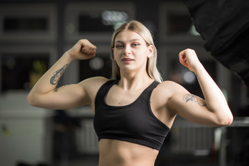 Portrait of a blond-haired girl with in the gym standing in a sports position.