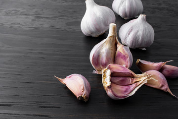 garlic cloves and bulb on wood background
