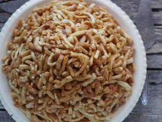 Ant hill cake made from chak chak, a Tatar treat with a teapot and honey, wooden natural background.