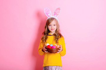 Happy Easter! Little girl having fun to paint Easter eggs.