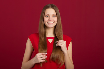 Obraz na płótnie Canvas portrait of a beautiful young woman on a red background