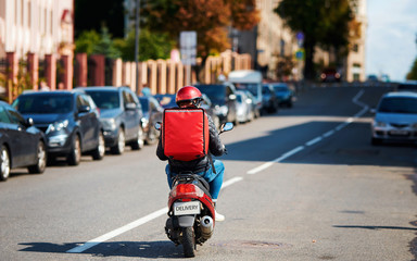 Deliveryboy on scooter with red backpack driving fast to customers, online orders. Courier...