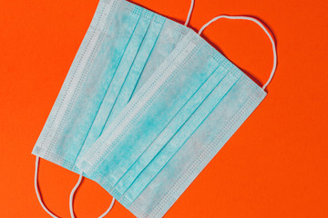 Disposable medical masks are antiviral and antibacterial on an orange background.