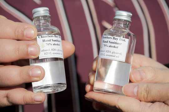 People hold their bottles of free hands sanitizer at Chambers Bay Distillery, which is creating the product with ethanol alcohol and giving it away, following reports of coronavirus disease (COVID-19) cases in the country, in University Place