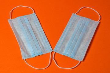 Disposable medical masks are antiviral and antibacterial on an orange background.