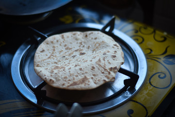 woman cooking a Indian chapati on gash  