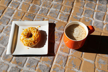 Cup of coffee and cake on a stone floor