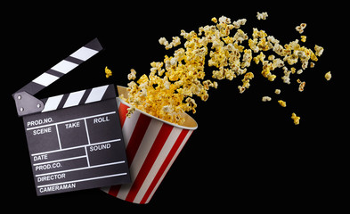 Flying popcorn from striped bucket isolated on black background