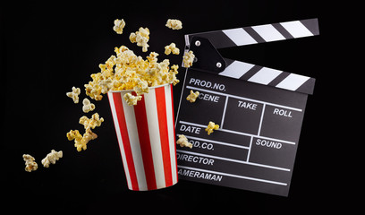 Flying popcorn from striped bucket isolated on black background