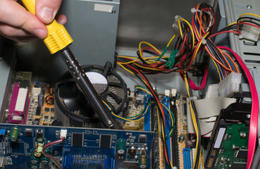 Computer engineer repairing a computer with a soldering iron