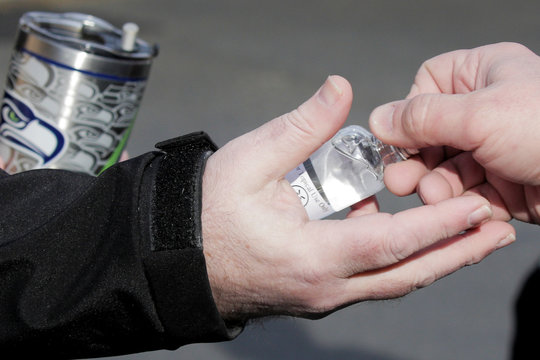 A person receives a hands sanitizer for free at Chambers Bay Distillery, which is creating the product with ethanol alcohol and giving it away, following reports of coronavirus disease (COVID-19) cases in the country, in University Place