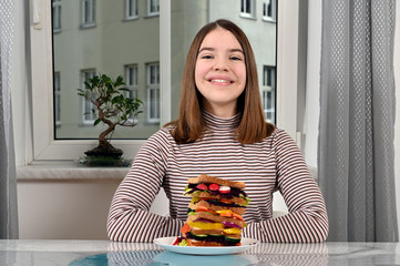 happy teenage girl with vegetarian sandwich at home