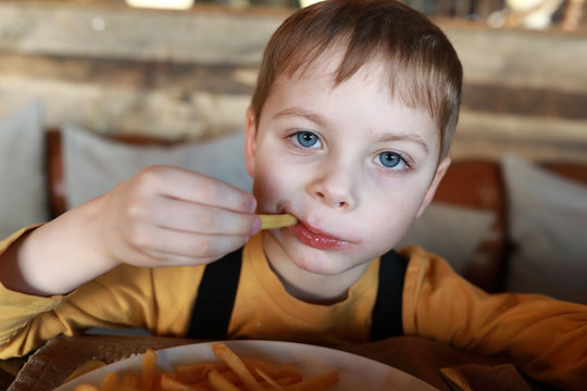 Child eats french fries with ketchup