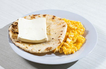 Colombian typical breakfast, cheese, eggs and arepa