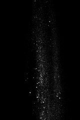 Started splash of white flour powder on black background.