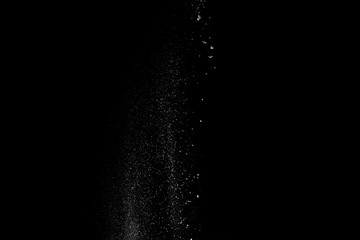Started splash of white flour powder on black background.