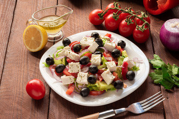 Greek salad with fresh cucumber , tomatoes, sweet pepper, lettuce, red onion, feta cheese and olives with olive oil. Healthy diet