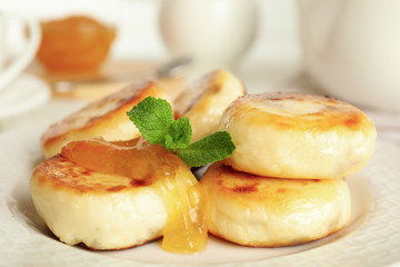 Delicious cottage cheese pancakes with mint on plate, closeup