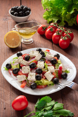 Greek salad with fresh cucumber , tomatoes, sweet pepper, lettuce, red onion, feta cheese and olives with olive oil. Healthy diet