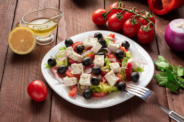 Greek salad with fresh cucumber , tomatoes, sweet pepper, lettuce, red onion, feta cheese and olives with olive oil. Healthy diet