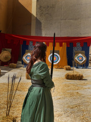 Mujer medieval lanzando con arco.