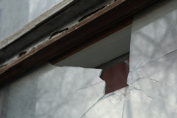 Broken window of abandoned house outdoors, closeup. Requiring repair