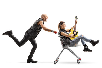 Punk shouting and pushing a shopping cart with a woman playing a guitar inside