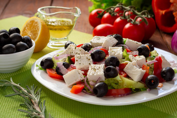Greek salad with fresh cucumber , tomatoes, sweet pepper, lettuce, red onion, feta cheese and olives with olive oil. Healthy diet