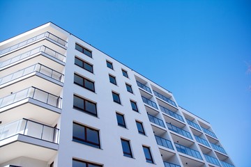 Obraz premium Modern apartment buildings on a sunny day with a blue sky. Facade of a modern apartment building