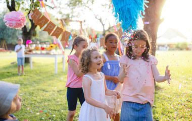 Fototapeta premium Small children outdoors in garden in summer, playing.
