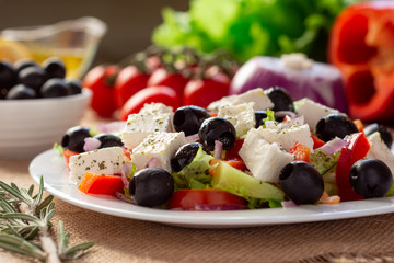 Greek salad with fresh cucumber , tomatoes, sweet pepper, lettuce, red onion, feta cheese and olives with olive oil. Healthy diet